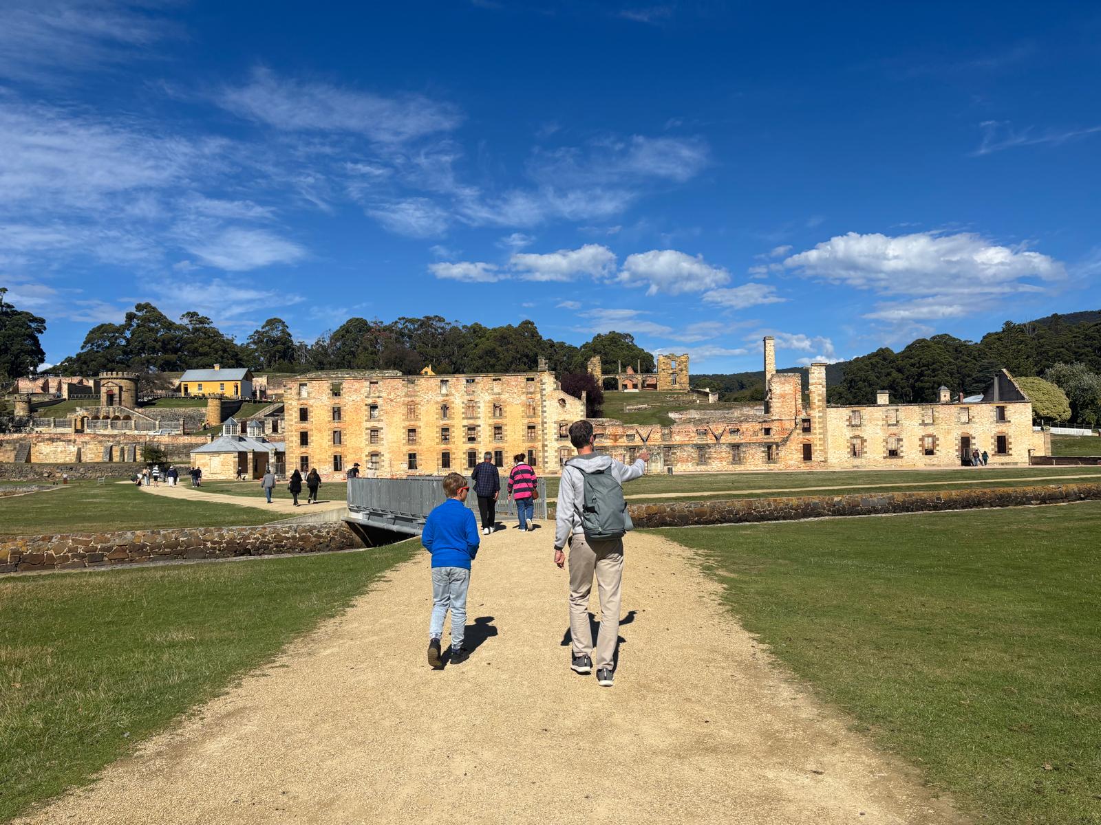 Father and son walking toward the convict ruins at Port Arthur historic site, Tasmania