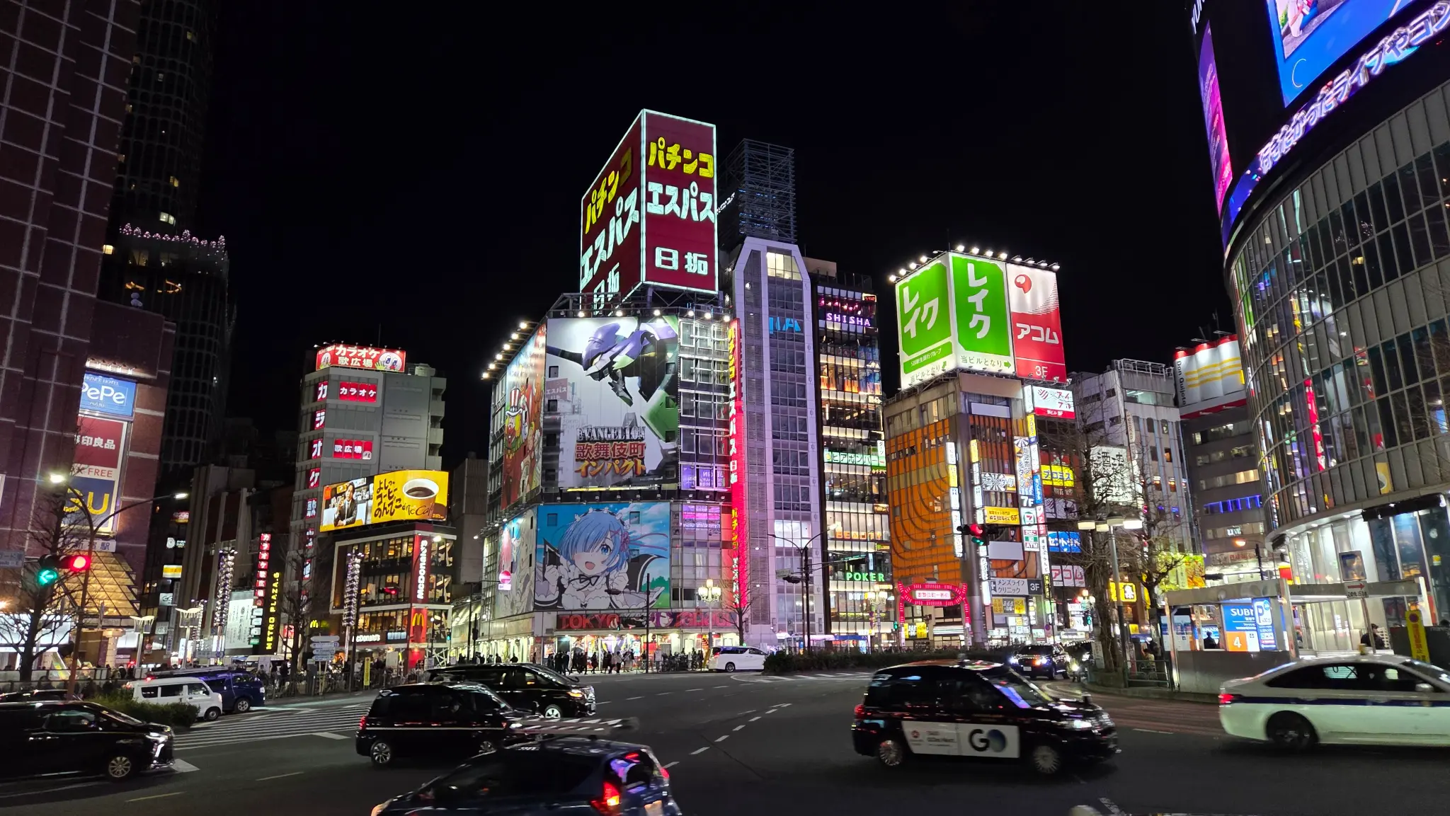 Shinjuku street at night with neon lights and billboard screens, Tokyo